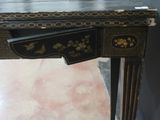 a black and gold desk with a drawer underneath it