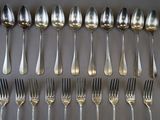a lot of silver spoons and forks on the table
