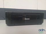 the canon printer is sitting on the table next to the wall