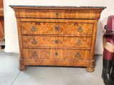 une commode ancienne dans une pièce, à côté d'un fauteuil