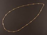 un collier à chaîne dorée orné d'un motif de nœud sur fond noir