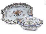 two plates and a bowl with a lid on a table