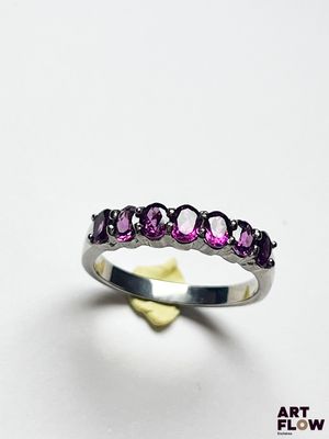 une image représentant une bague ornée de pierres violettes sur un fond blanc