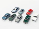 several toy cars are lined up in a row on a white surface