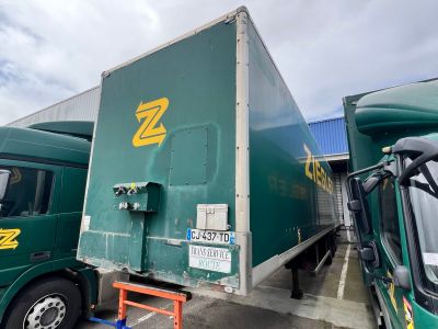 deux camions verts garés l'un à côté de l'autre sur un parking