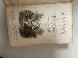an old book with a picture of a woman holding a child