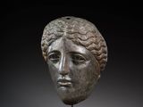 une tête de femme en bronze posée sur un socle en bois