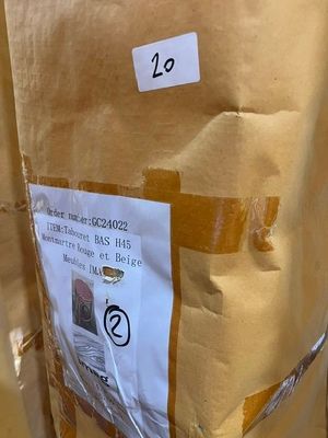 un sac en carton sur lequel est collé un autocollant, posé par terre