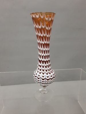 a glass vase that is sitting on a glass shelf