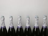 six bottles of sparkling wine lined up in a row on a table