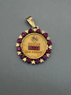 a close up of a gold coin with purple stones on it