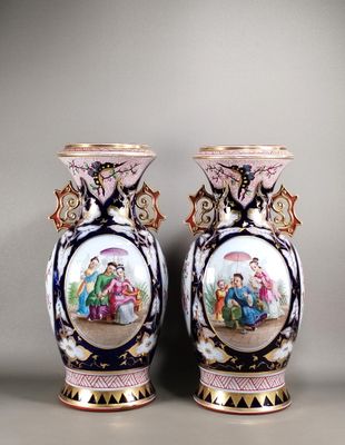 deux vases ornés d'une peinture représentant des personnes, posés sur une table