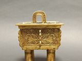 an image of a gold incense box on a gray background