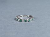 a white gold ring with emerald stones and diamonds