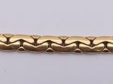 a close up of a gold chain on a white surface