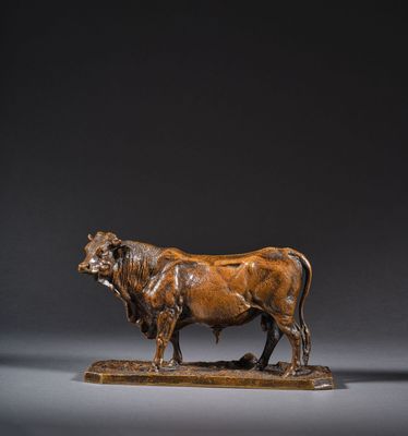 une sculpture antique en bronze représentant un taureau, posée sur un socle en bois