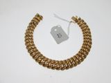gros plan d'un bracelet en or portant une étiquette de prix