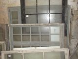 many old windows in the corner of a room