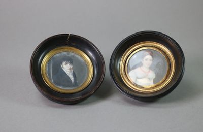 pair of miniature portraits of a woman and a man in a black and gold frame
