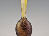 a glass vase with a design of leaves and flowers on it