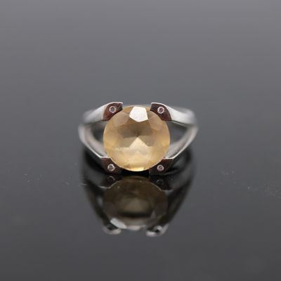 un gros plan d'une bague ornée d'une pierre jaune sur un fond noir