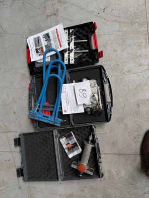 une valise remplie d'outils posée par terre à côté d'une paire de chaussures