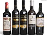 several bottles of wine are lined up on a white surface