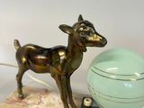 a statue of a deer that is standing next to a bowl