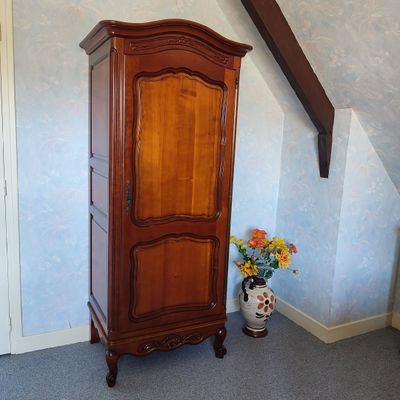 a tall wooden cabinet in the corner of a room