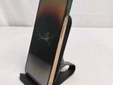 the back of a black and gold phone on a stand on a white surface