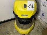un aspirateur jaune posé par terre à côté d'un carton