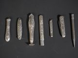 six types différents de couverts sont disposés en rangée sur une surface noire
