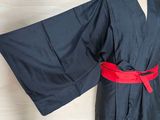 a black robe on a mannequin with a red belt