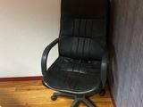a black office chair sitting in the corner of a room