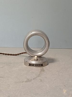 un petit objet en argent posé sur une table, avec une corde