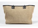 a large beige bag with black handles and a zipper closure