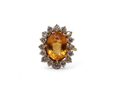 un gros plan d'une bague ornée d'une grosse citrine entourée de petits diamants