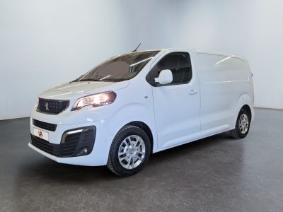 La petite camionnette blanche est garée dans une grande pièce.
