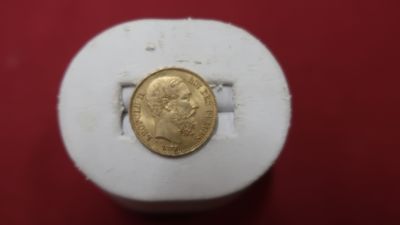 une pièce d'or posée sur une boîte blanche
