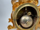 a gold clock that is sitting on a table