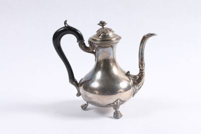 une théière ancienne en argent avec une poignée noire sur fond blanc