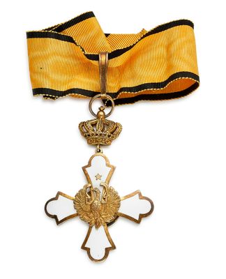 une image représentant une croix en or surmontée d'une couronne