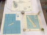 three maps of new zealand displayed on a table in a workshop