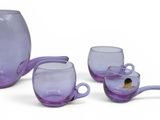 trois verres violets et une cuillère posés sur une surface blanche