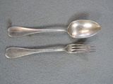 two spoons and a fork sitting on a table