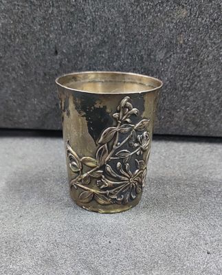 a silver cup with a bird on it on a table