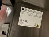 a sign on the side of a stainless steel refrigerator