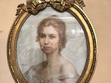 portrait of a woman in a white dress in a gold frame on a wall
