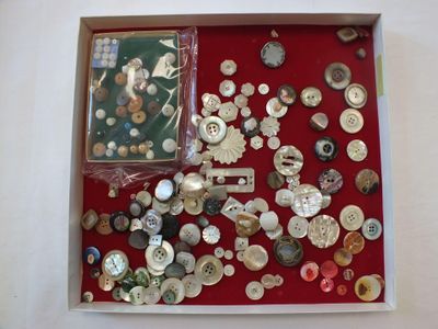 plein de boutons dans une boîte posée sur la table