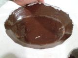 une personne tenant une cuillère au-dessus d'un bol de chocolat fondu